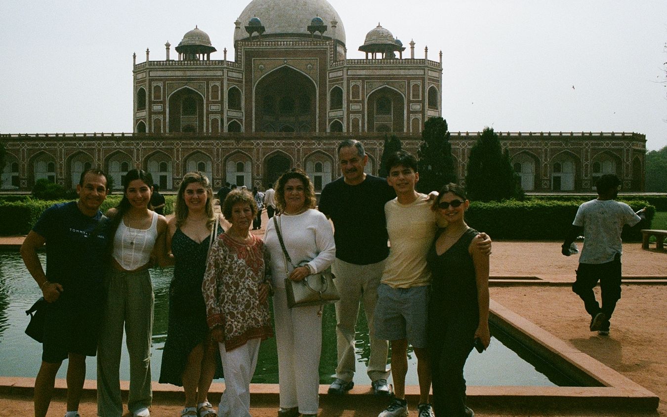 Una familia de ocho viajeros posando frente a la tumba de Humayun, en Delhi
