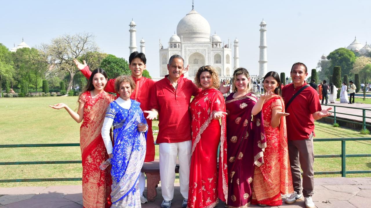 Un grupo de viajeros latinos vestidos con saris frente al Taj Mahal