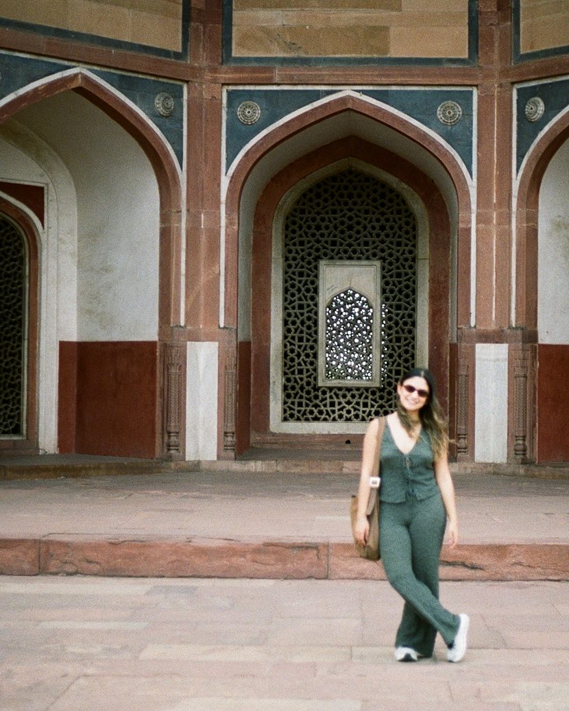 Una viajera caminando bajo los arcos de la tumba de Humayun, en Delhi